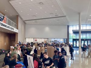 Students gather at the Club Fair to find one that interests them. Leaders encourage students to join their clubs with information trifolds. 