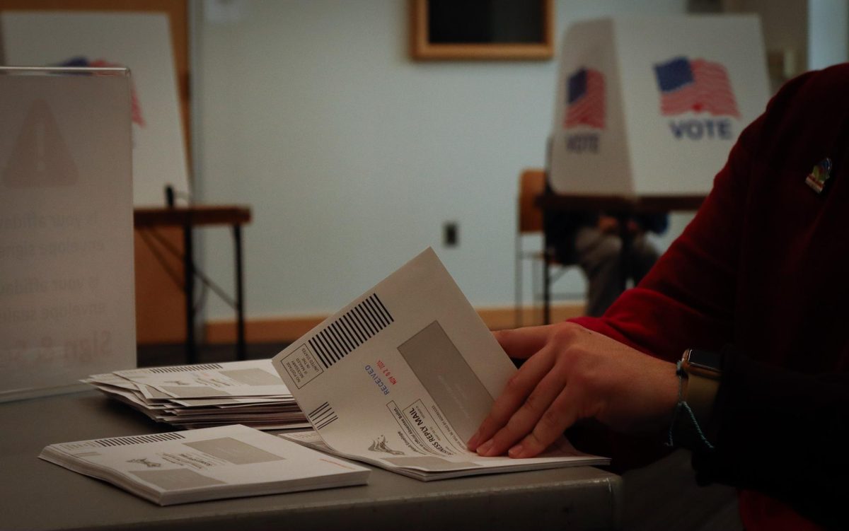 A voting official sorts through envelopes for ballots.